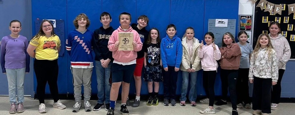 Archery students standing in a group celebrating their achievement at their archery competition.