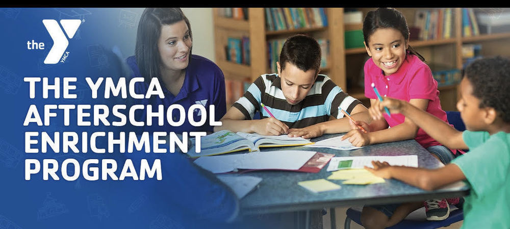 YMCA after school enrichment program. A teacher and students working at a table.