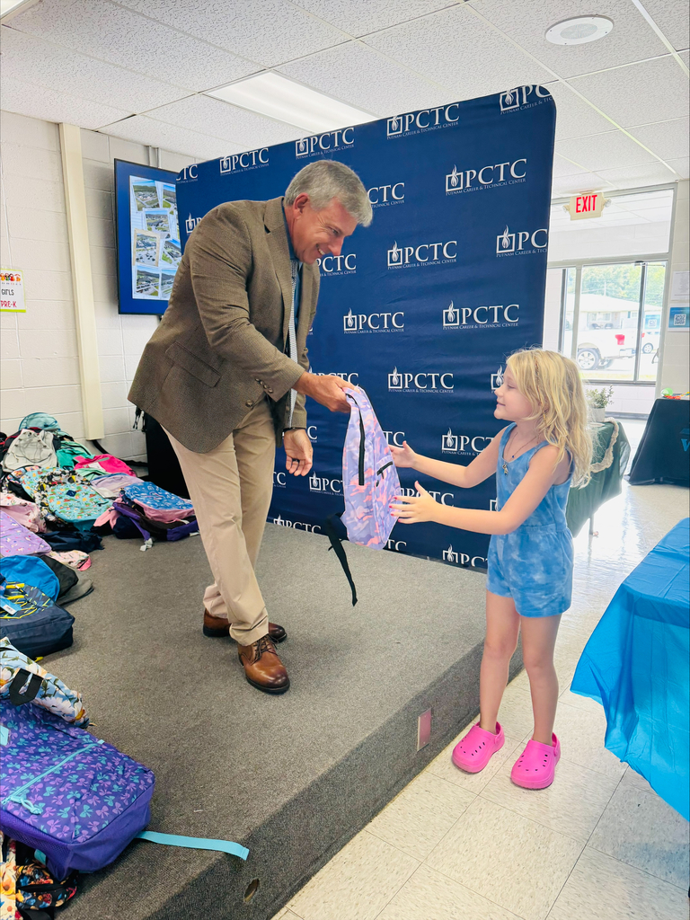 Mr. McGrew hands student backpack for Back to School Blast