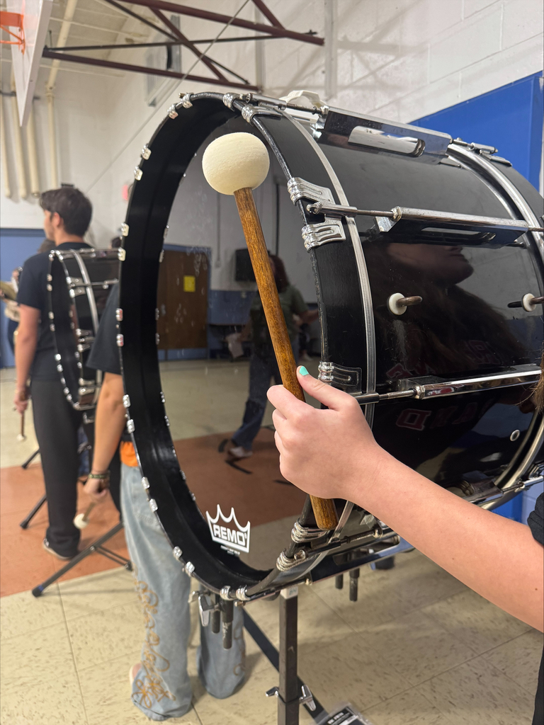 Image of student playing drum in drum line. 