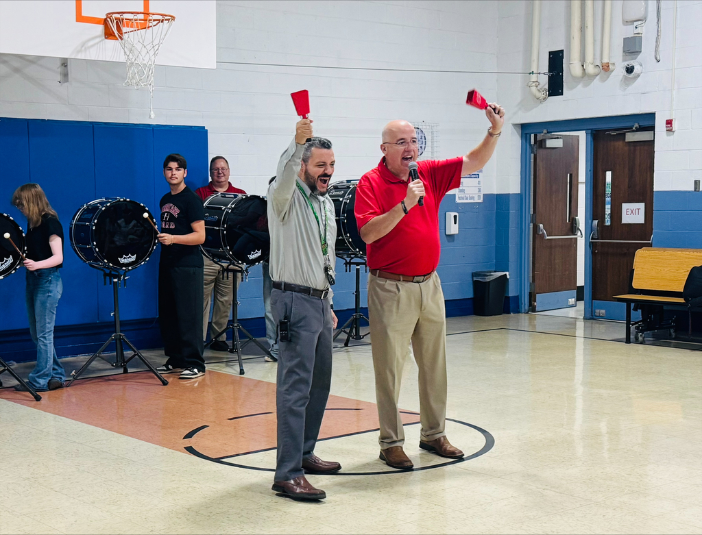 Dr. M and Mayor Edwards shake red cowbell to get students excited about coming to school each day. 