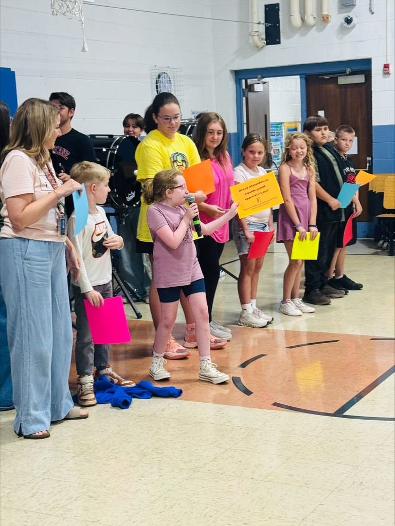 Students and teachers in a line reading signs of why attendance matters. 