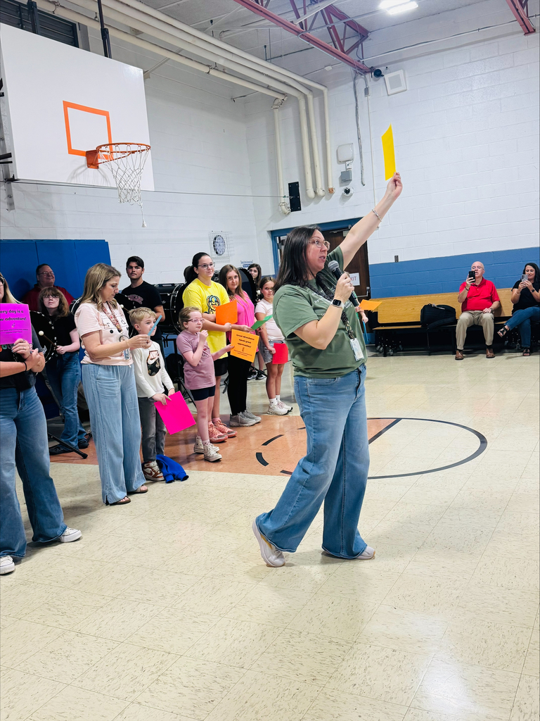Ms. Amick holds up one of the attendance signs to students 