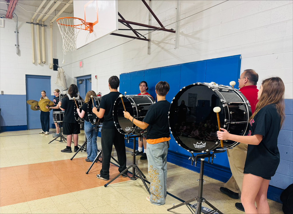 Members of HHS drumline playing for LES students.
