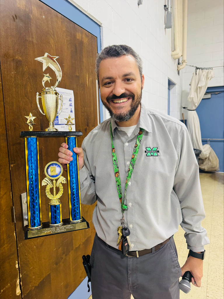 Dr. M holds attendance trophy that students will compete for each week. 