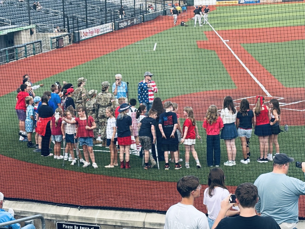 Mr. Skiles and Choir on the baseball field preparing to sing the National Anthem 