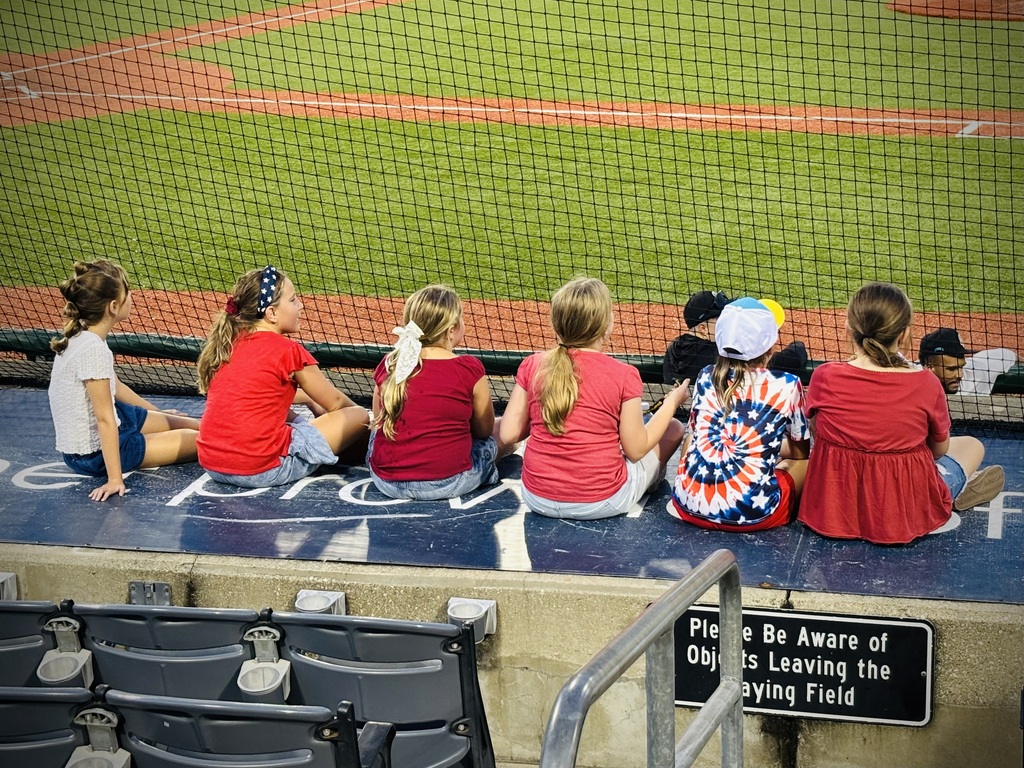 RBE Choir Members sit on the side to watch the baseball game 