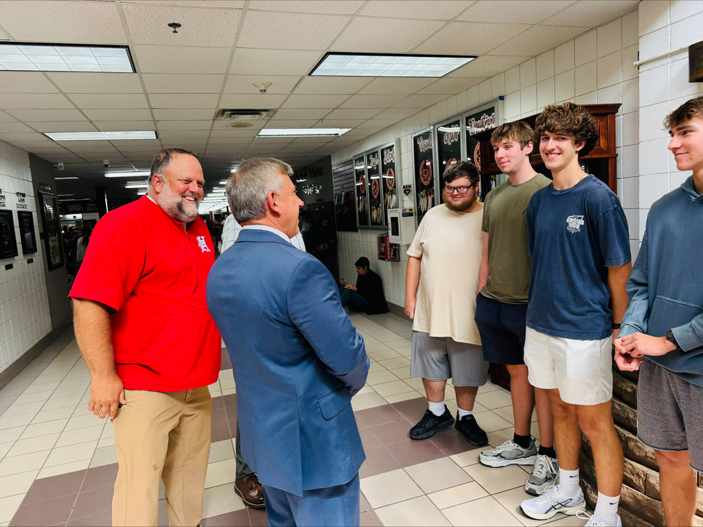 Mr. Caldwell and Mr. McGrew laugh with finalist 