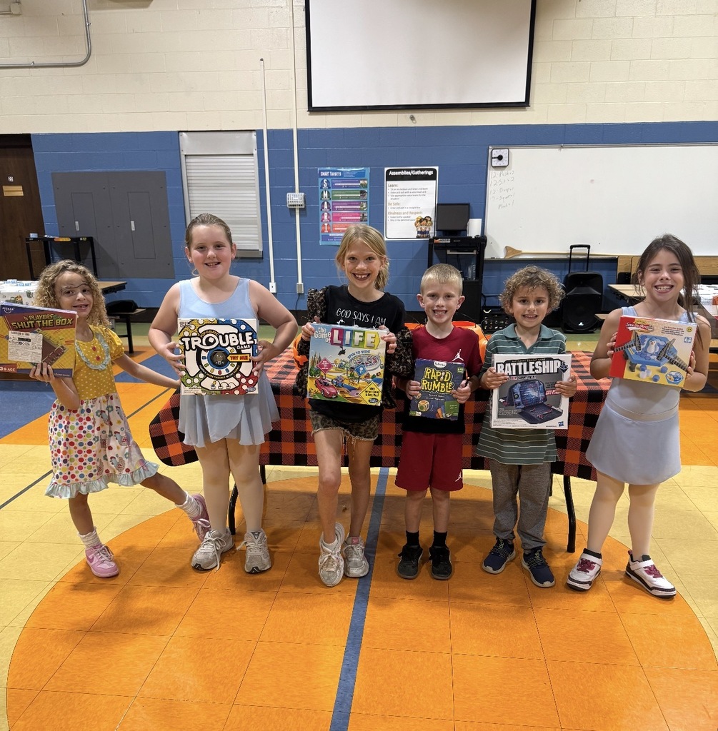 Students standing with board games on EES family night