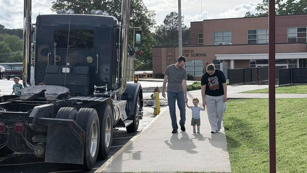 Parents walking beside semi-Truck