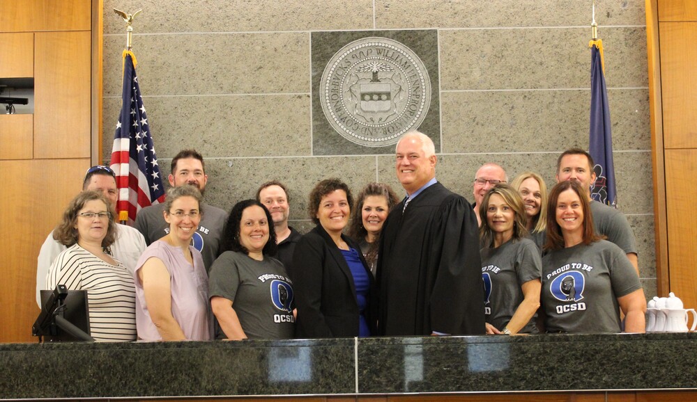 Dr. Hoffman smiles with Judge Weintraub, board members and adminstrators while taking the oath of Superintendent.