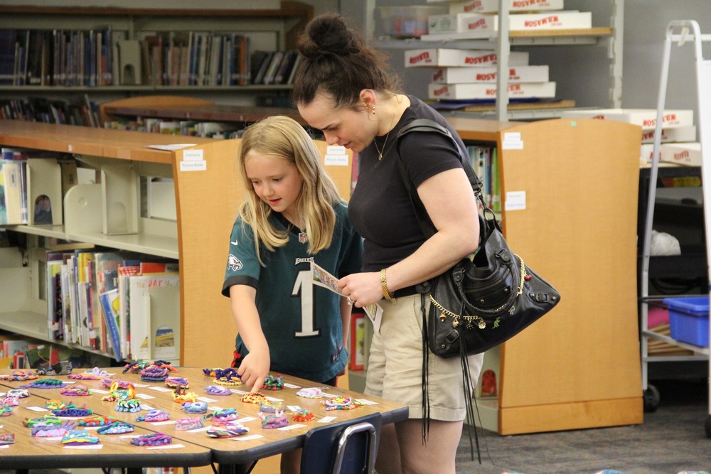 Students show their family members their artwork