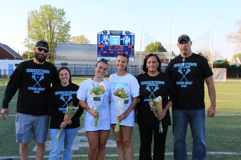 The senior players smiling with their parents on the field.