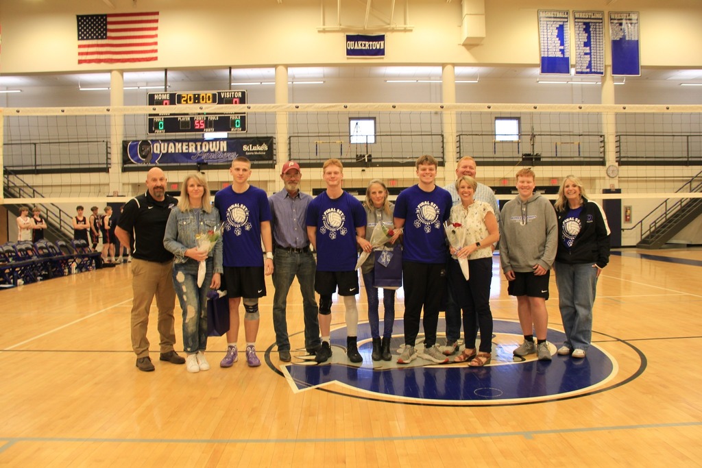 Senior Volleyball players smile for a photo with their families.