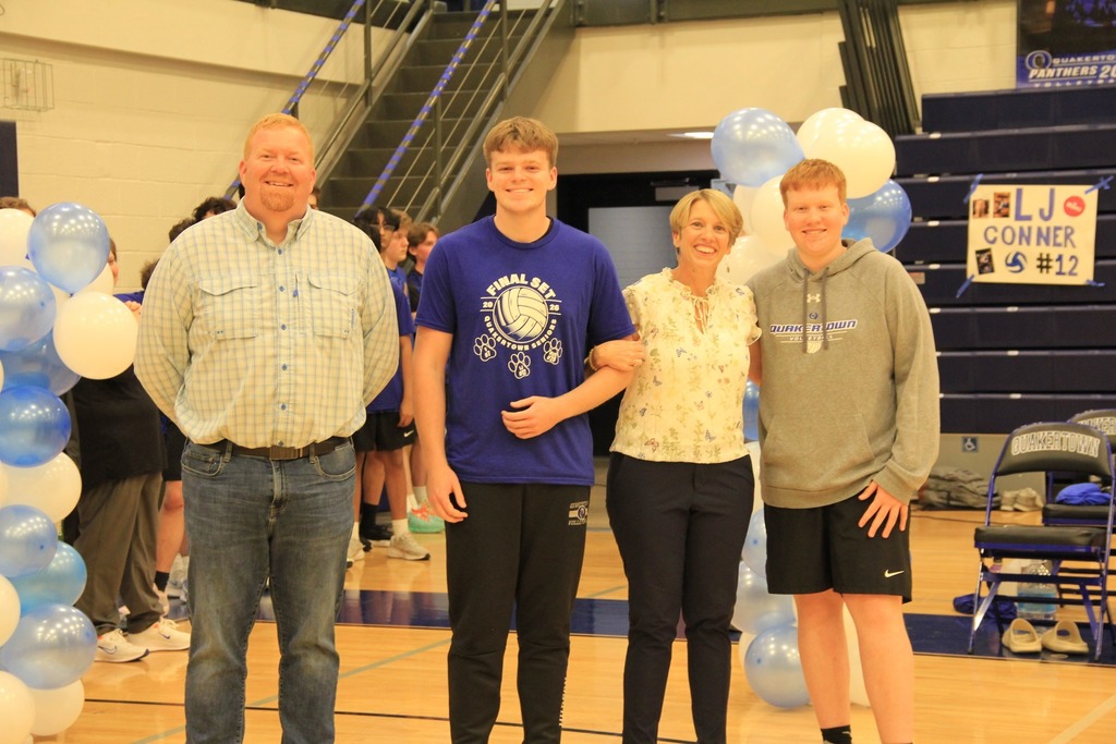 Senior Volleyball player smilea with his family photo.