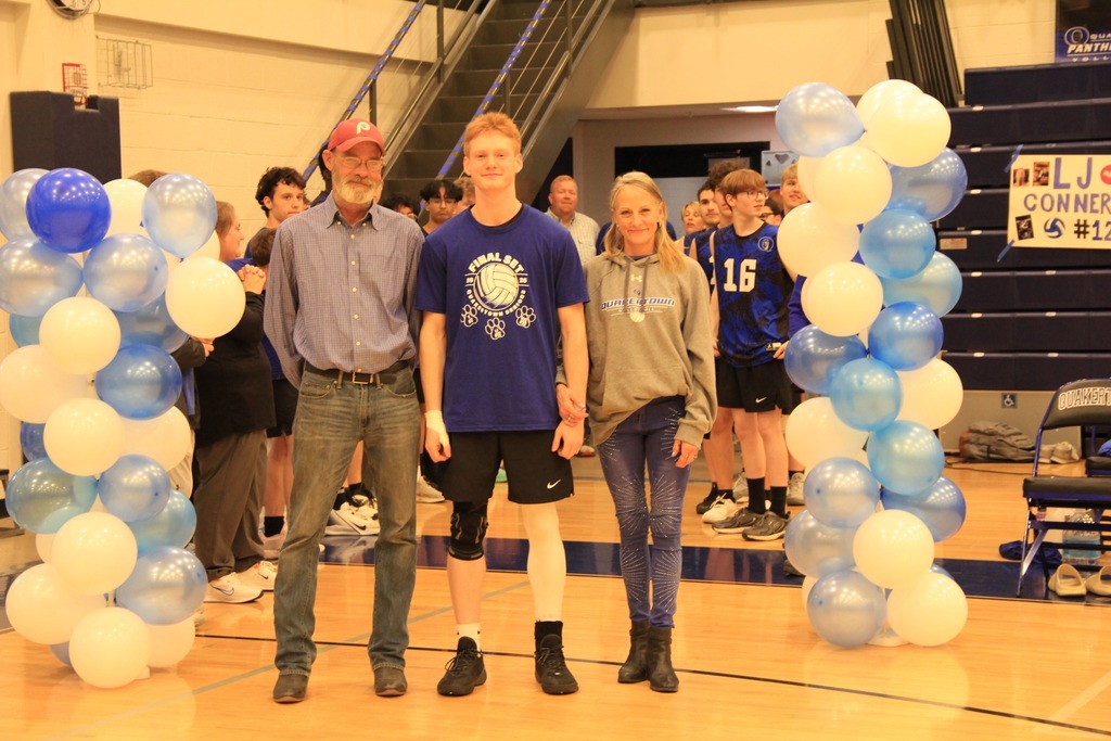 Senior Volleyball player smilea with his family photo.