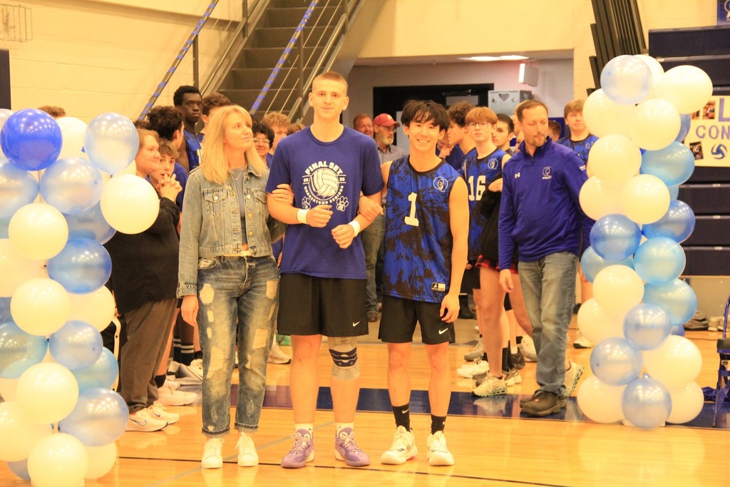 Senior Volleyball player smilea with his family photo.