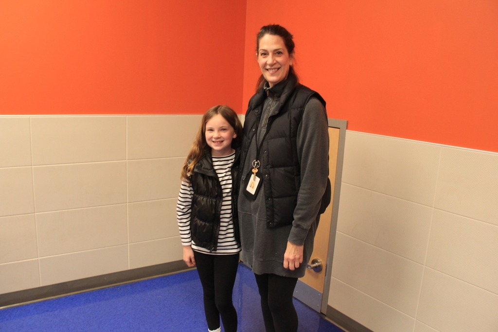 Both teacher and student are wearing black vests and black pants