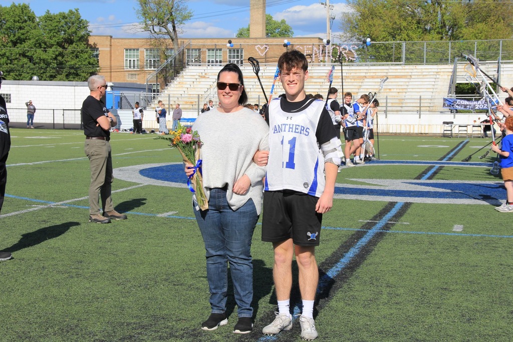 Cameron Beaudoin smiles for a photo with his mom on the field.