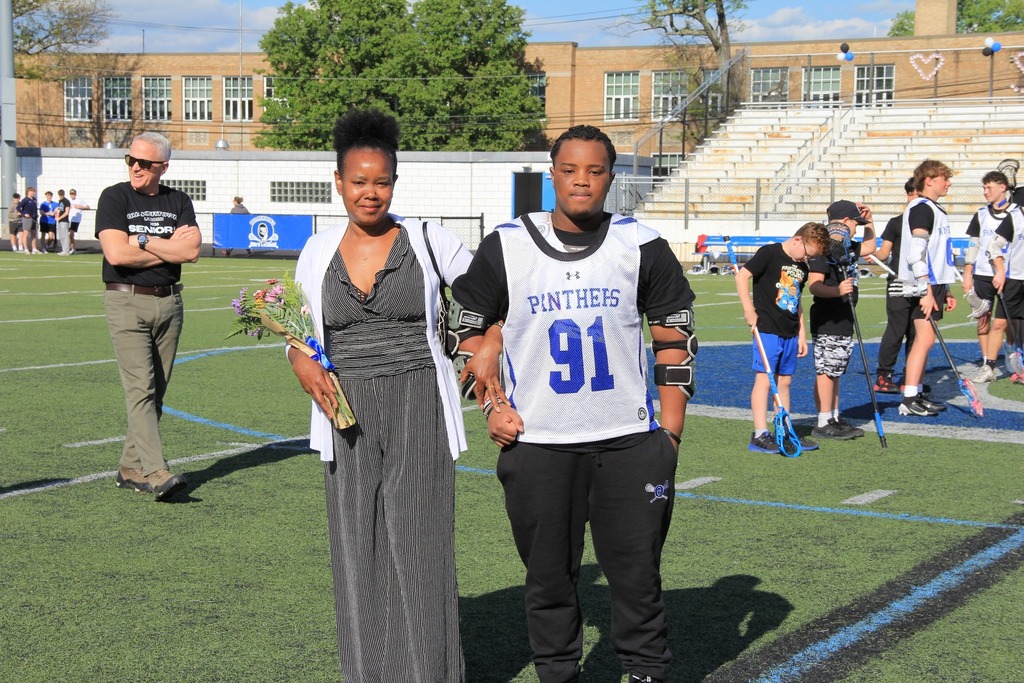Nigel Mutembei smiles with his mother on the field.