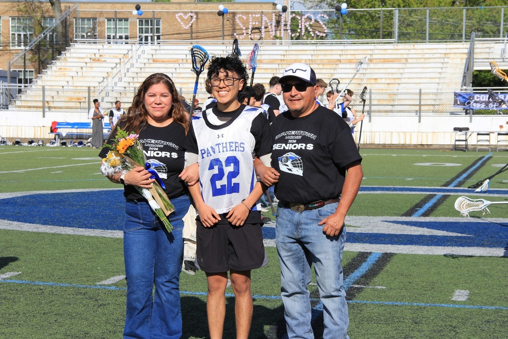 Alexander Sanchez smiles for a photo with his family on the field.