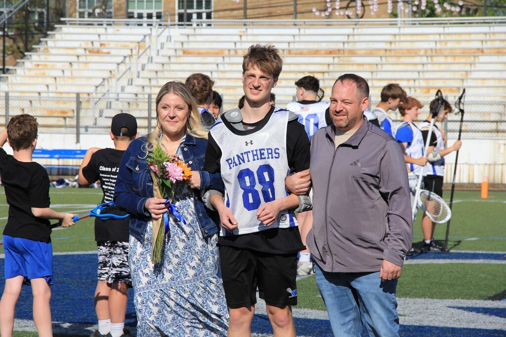 Dominik Whisenhunt smiles with his family on the field.