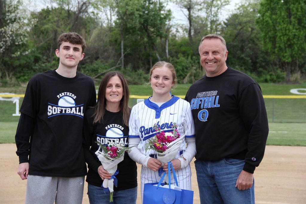 Kayla Scheibenhofer smiles with her family on the field.