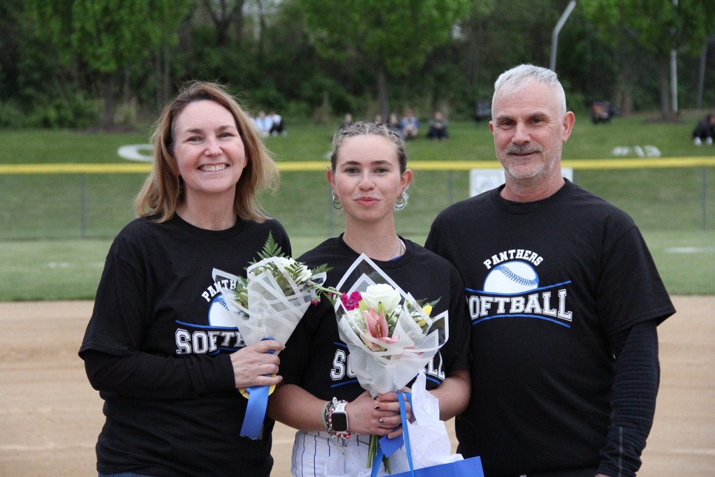 Katie DeSpirito smiles with her family on the field.