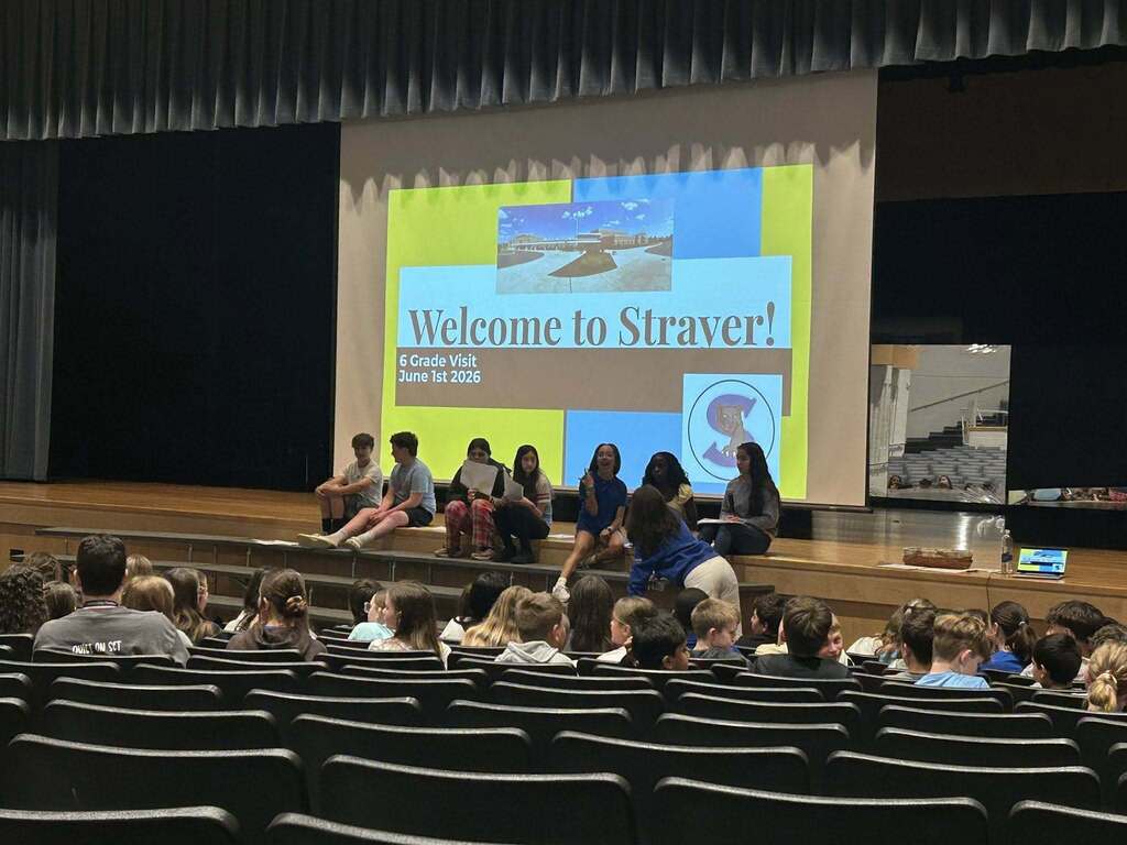 Students discuss the ins and outs of Strayer Middle School with sixth grade students in the auditorium