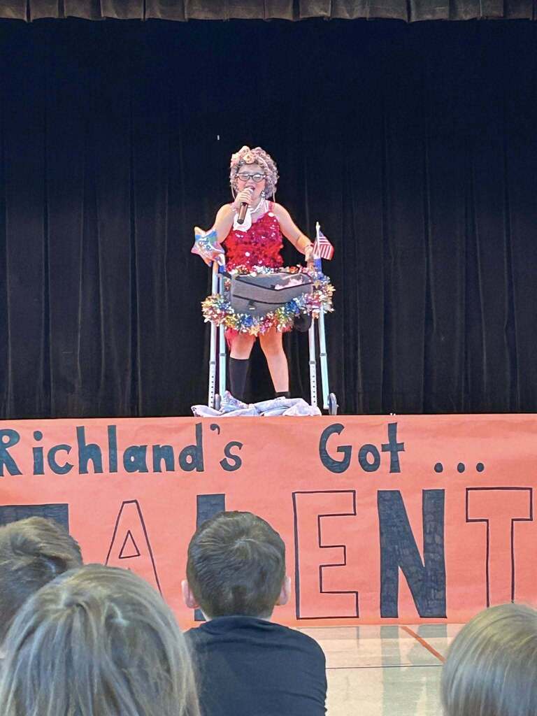 A student comedian performs  on the stage at Richland