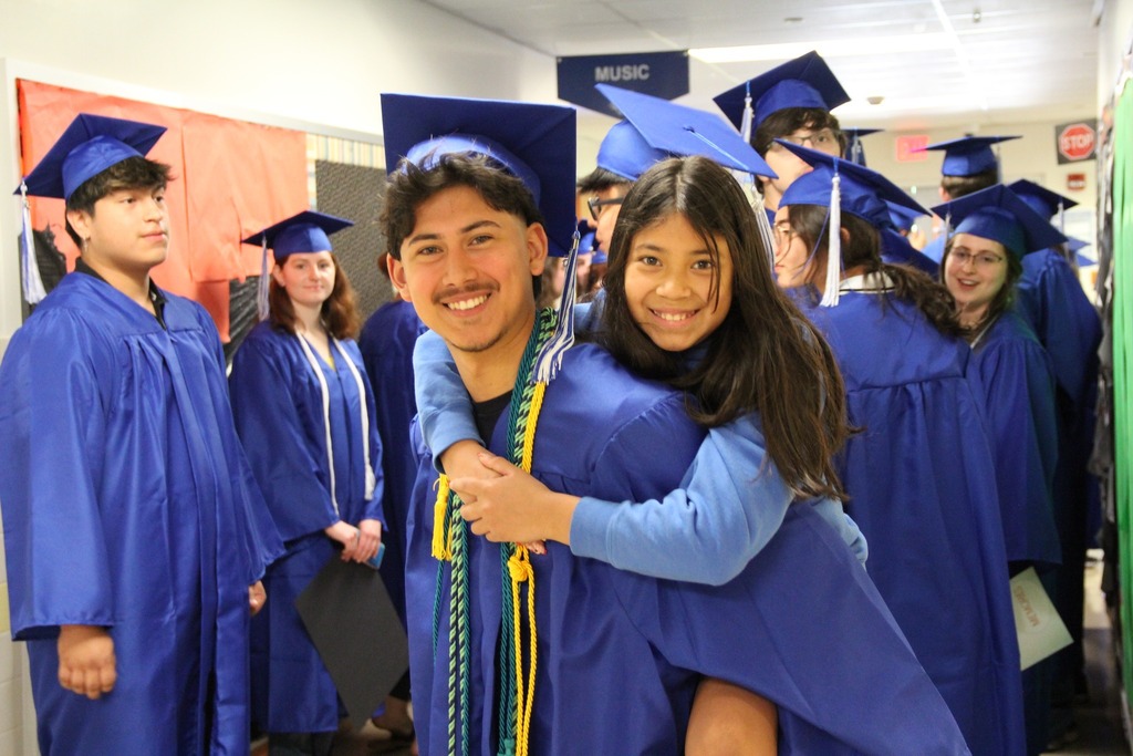 Senior Wilson Martinez gives his little sister a piggyback ride in the halls of Richland Elementary 