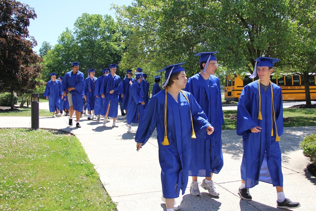 Seniors in their caps and gowns enter Trumbauersville Elementary