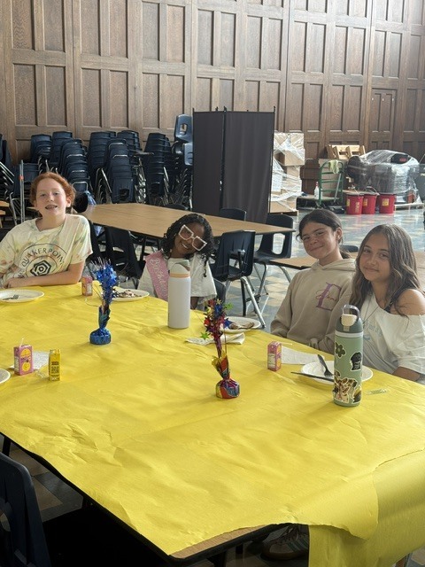 Students seated at decorated tables enjoying their pancakes