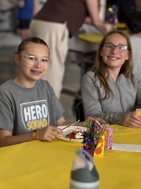 Students seated at decorated tables enjoying their pancakes