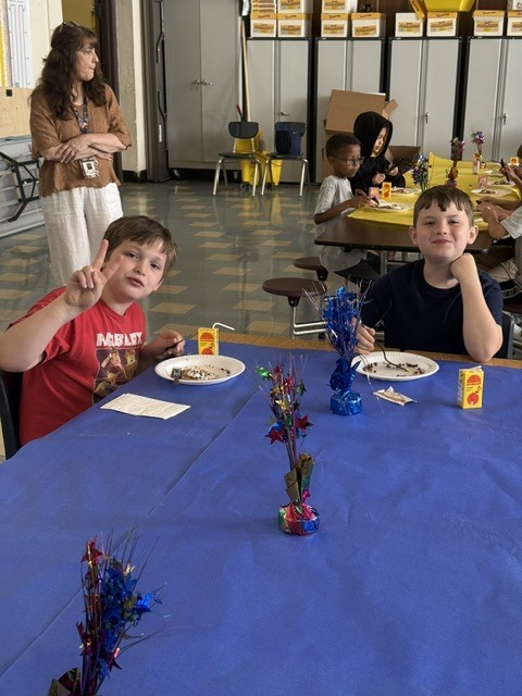 Students seated at decorated tables enjoying their pancakes