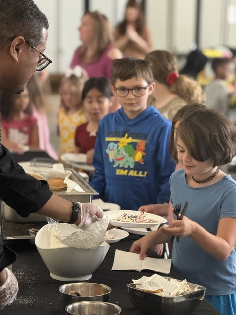 Students are being served pancakes