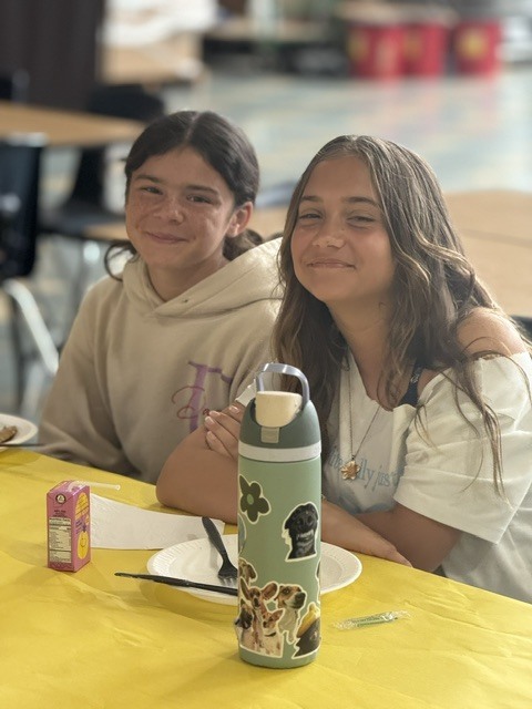 Students seated at decorated tables enjoying their pancakes