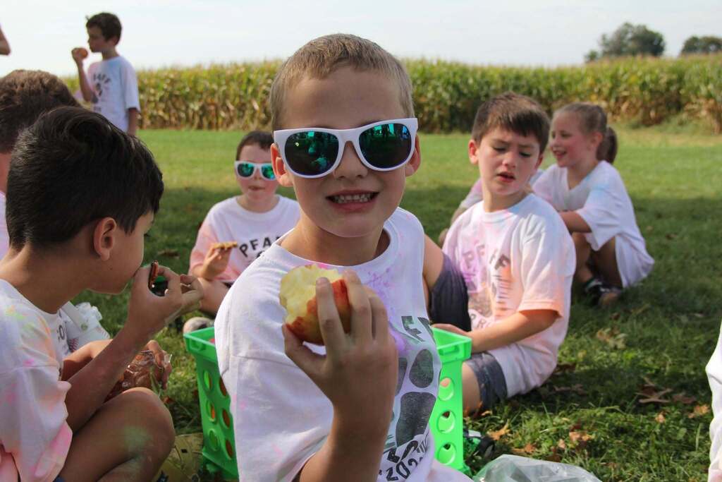 A child smiling while eating an apple