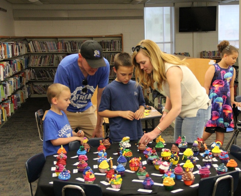 Families admire artwork in the library