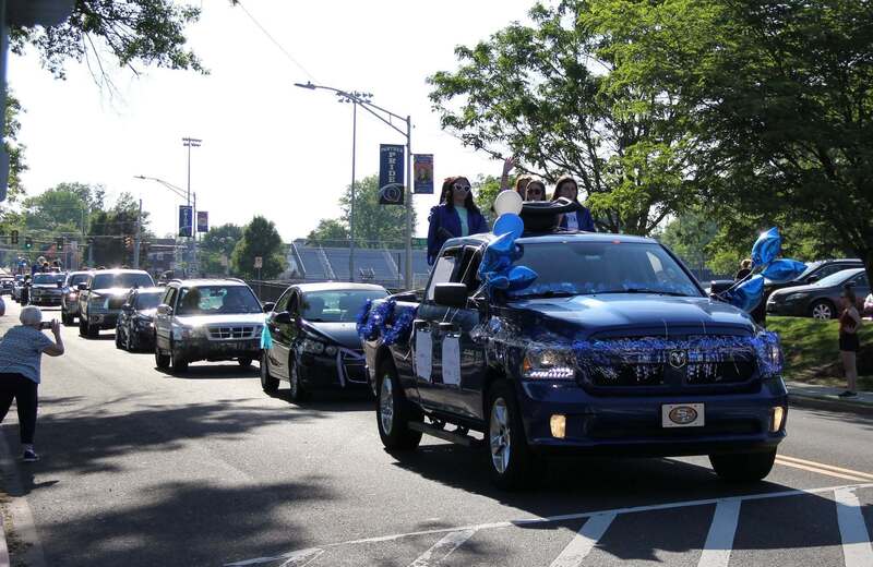 A procession of decorated vehicles makes its way down the road