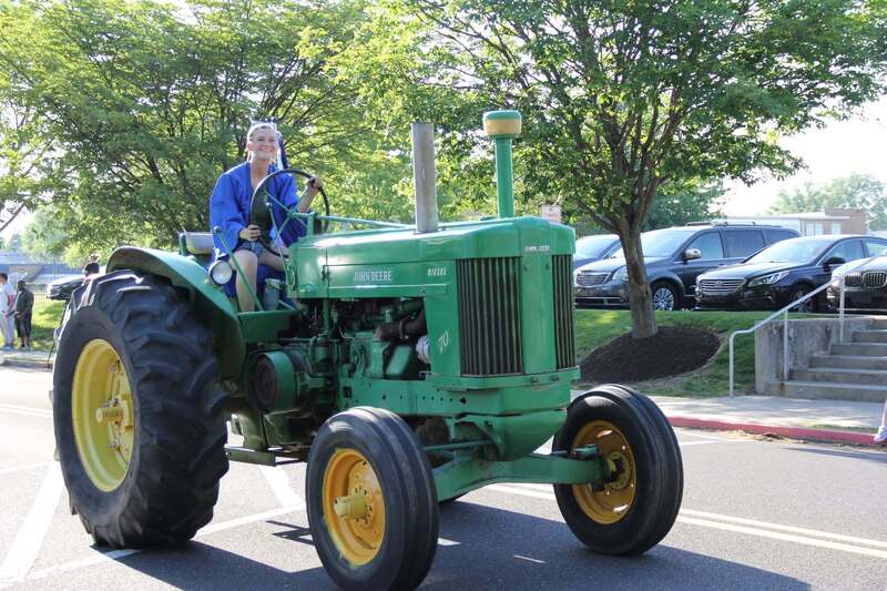 Student waves from her tractor