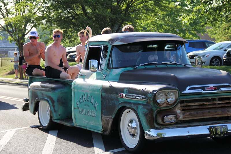 Students sit in the back of a classic pick up truck