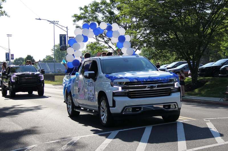 A decorated white truck with blue and white balloons