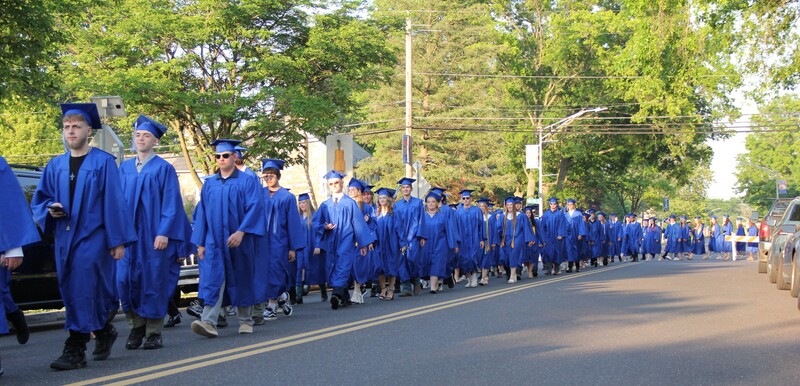 Students walk on Park Avenue to Alumni Field for graduation