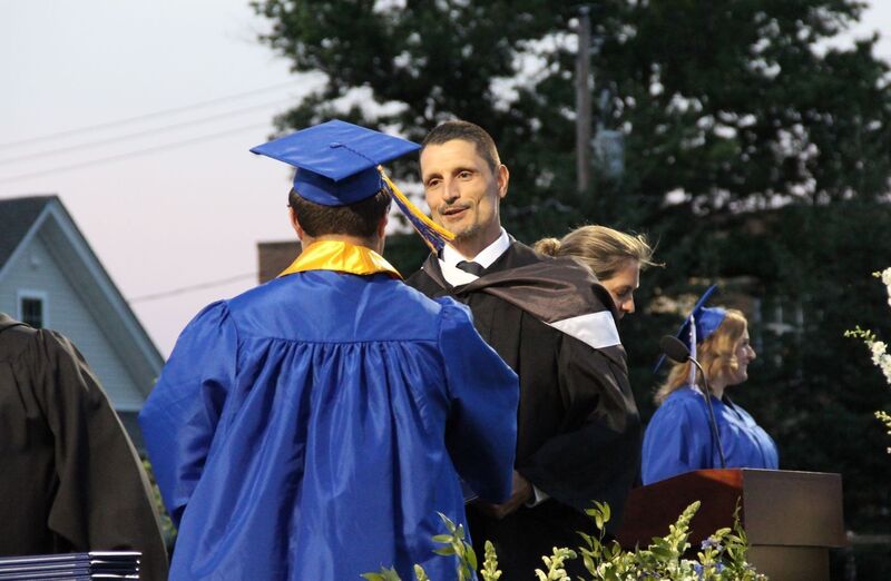 Owen Breininger shakes hands with graduates