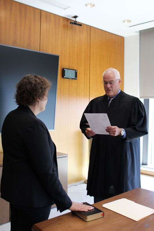 Dr. Hoffman taking the oath of Superintendent with her hand on the bible and Judge Weintraub