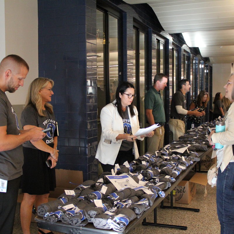 Principals  giving staff members tshirts