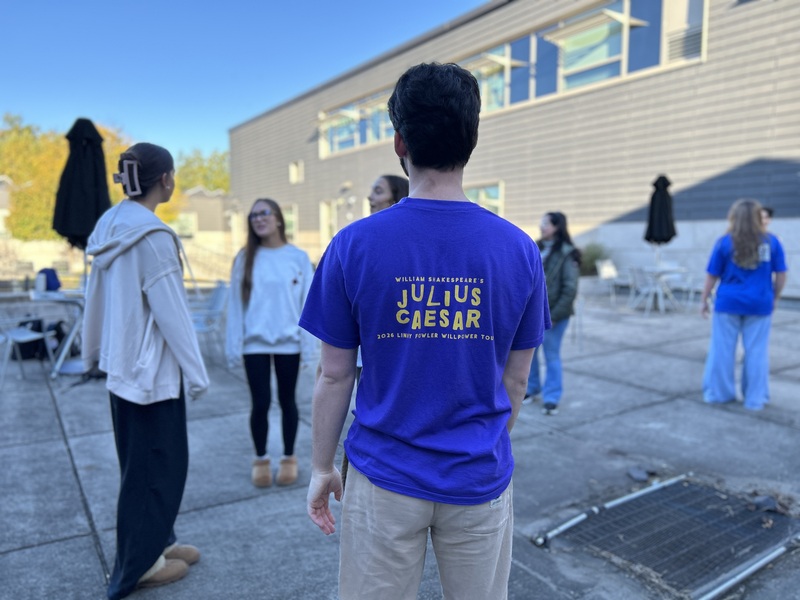 Students working together outside in small groups, with an instructor from WillPower wearing a "Julius Caesar" tshirt
