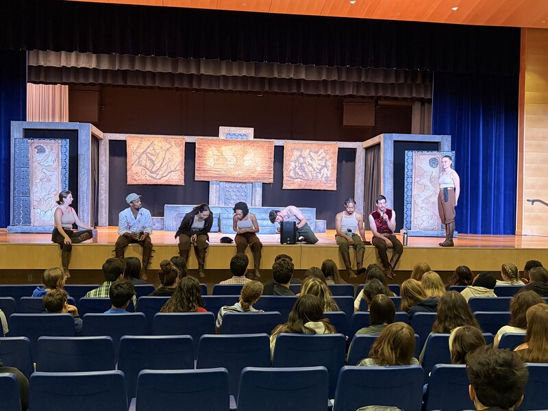 Students ask the actors questions as they sit at the front of the stage after the performance