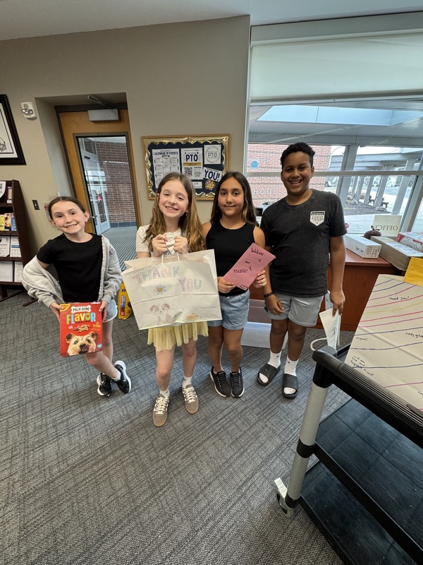 Fifth Grade leaders at Pfaff pause to smile for a photo while they organize their donations.